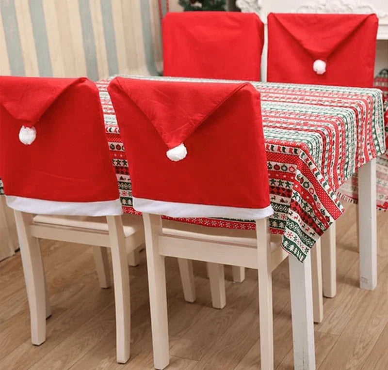 Santa hat dining chair covers around a table with a festive tablecloth
