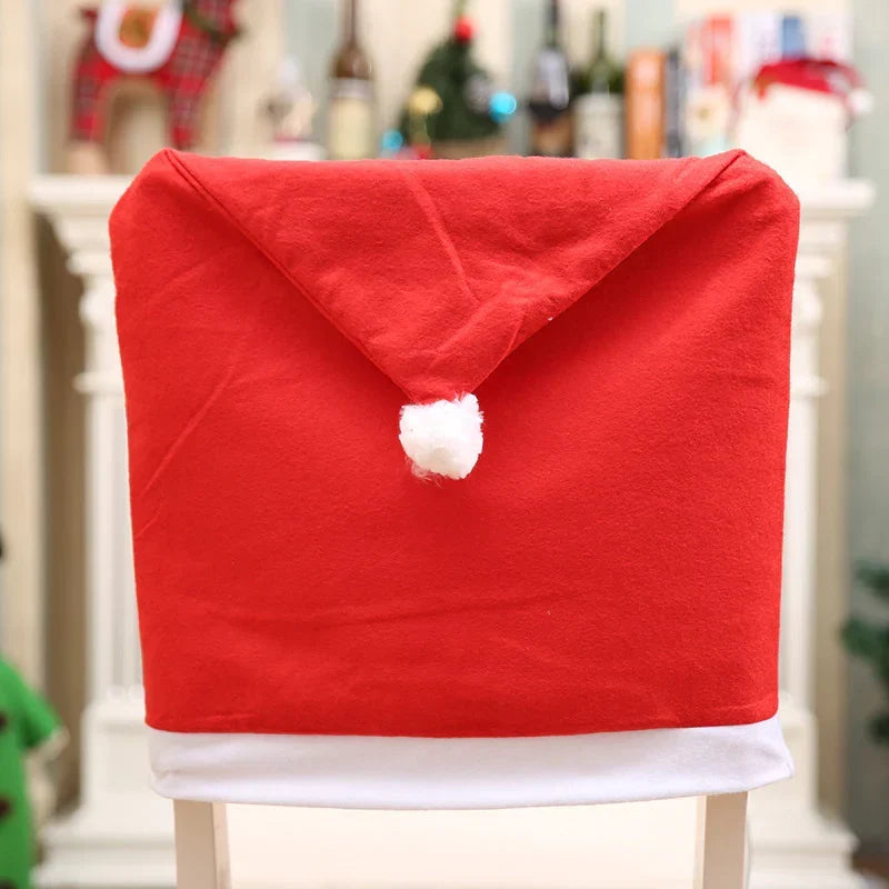 Red Santa hat chair cover with white pom pom on a white dining chair
